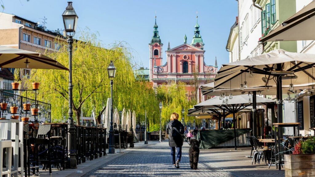 A lady walks her dog down empty streets in Ljubljana</em>