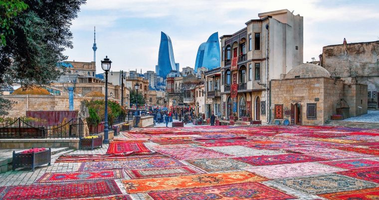 Colourful carpets with a backdrop of the Flame Towers in Baku, Azerbaijan