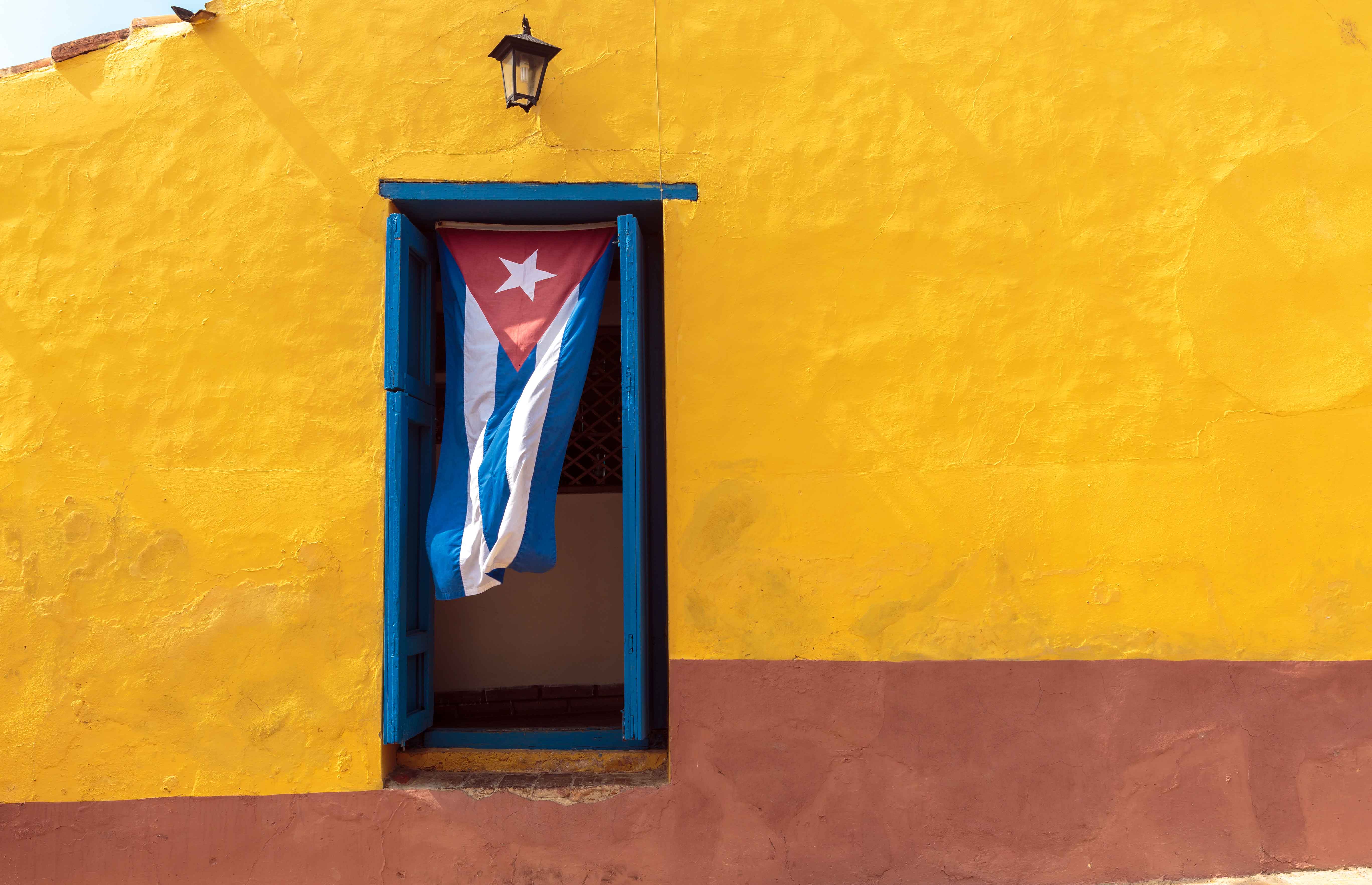 A Cuban flag hangs in a window in Old Havana